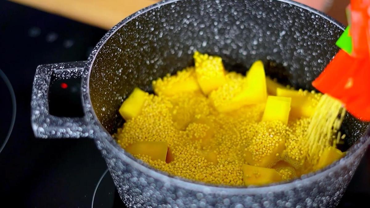 В кастрюлю с кусочками тыквы насыпают пшено из пакета