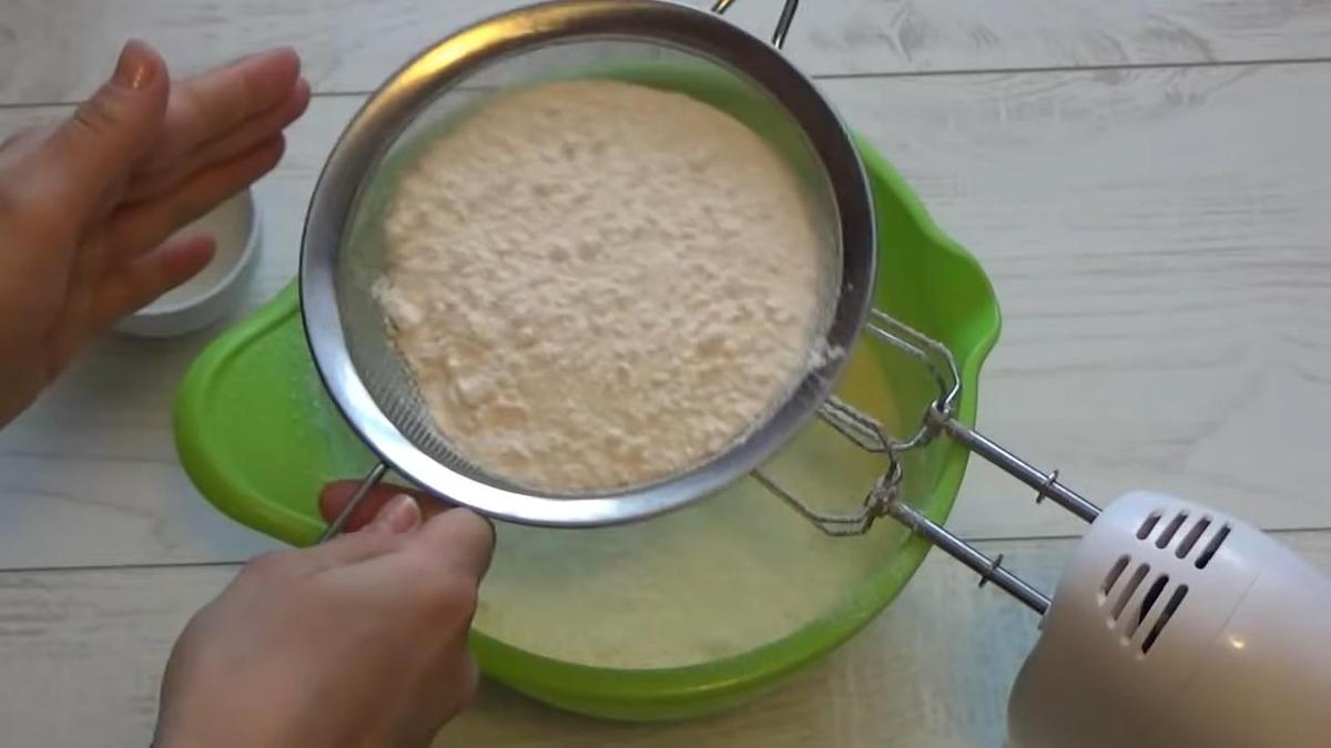 Муку просеивают в тесто через сито