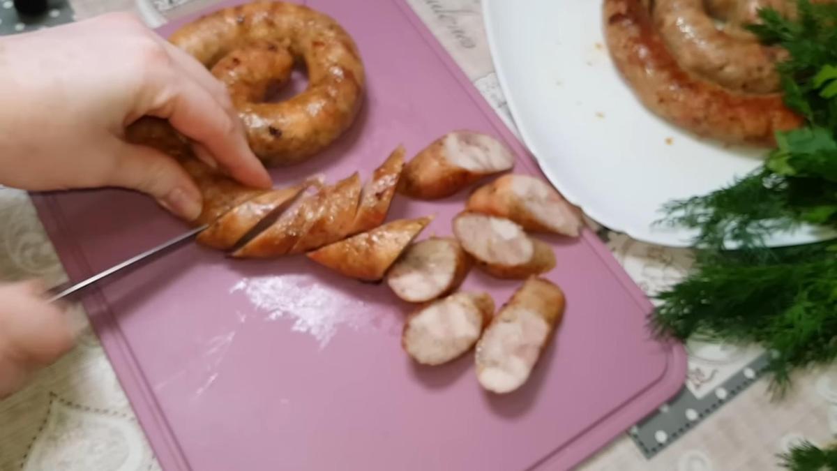 На разделочной доске нарезают колбасу