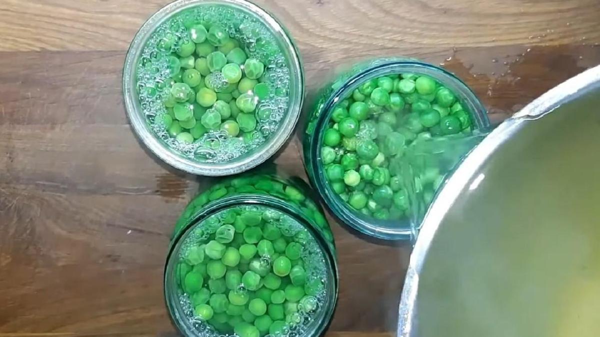 Добавление горячего рассола в банки с горошком