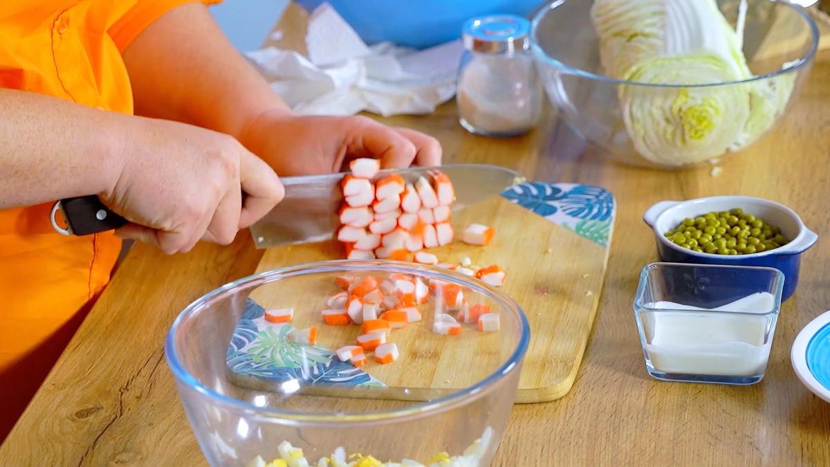 Нарезка крабовых палочек на разделочной доске