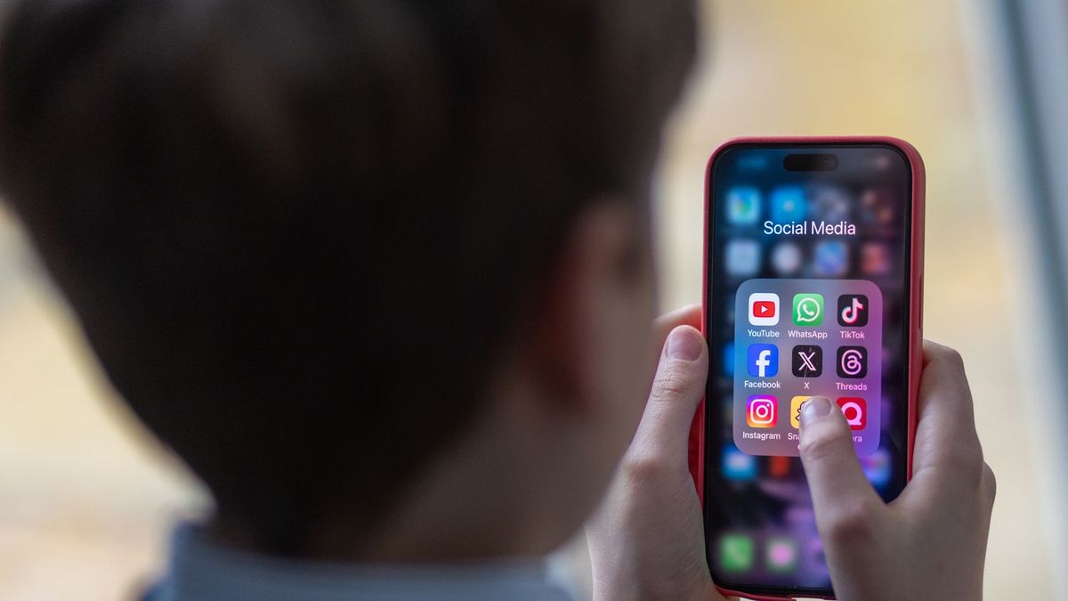 телефон ұстап отырған оқушы