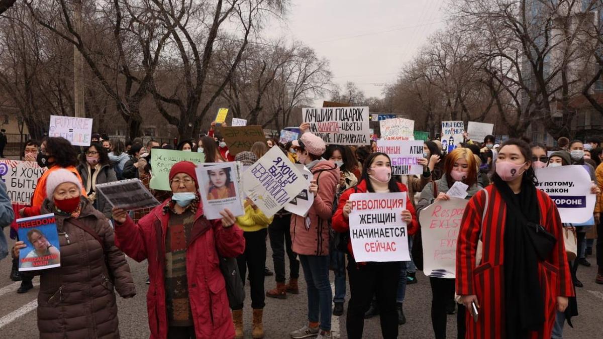 люди с плакатами на марше феминисток в Алматы