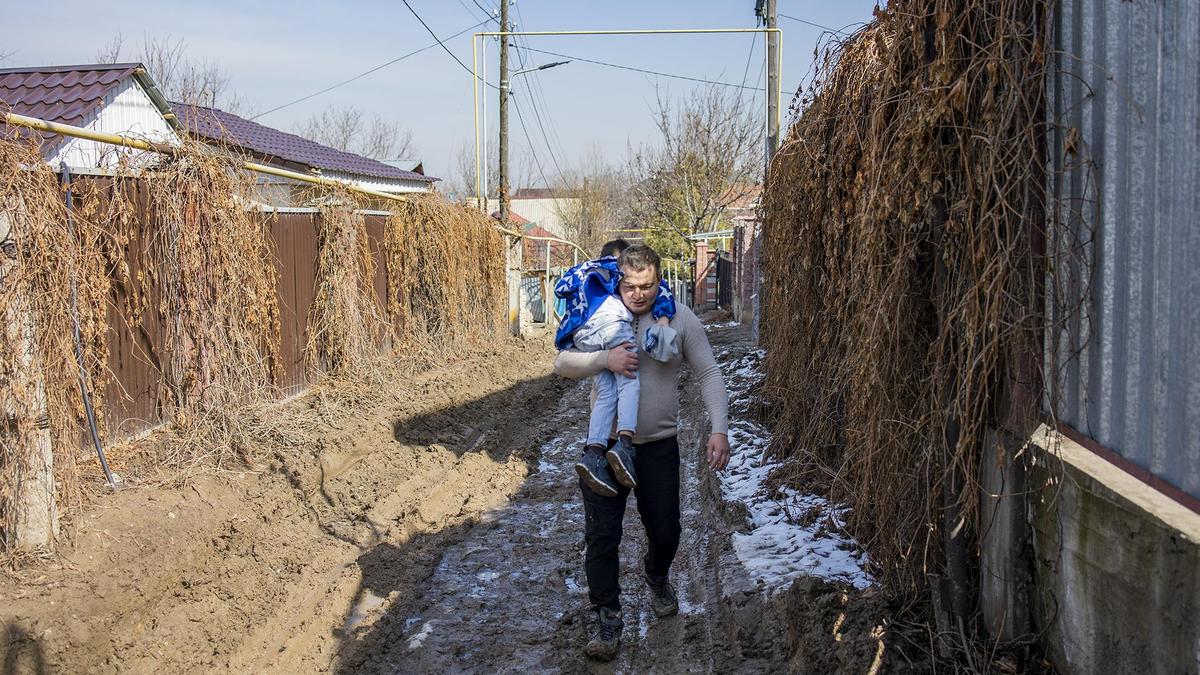 Мужчина несет ребенка на руках