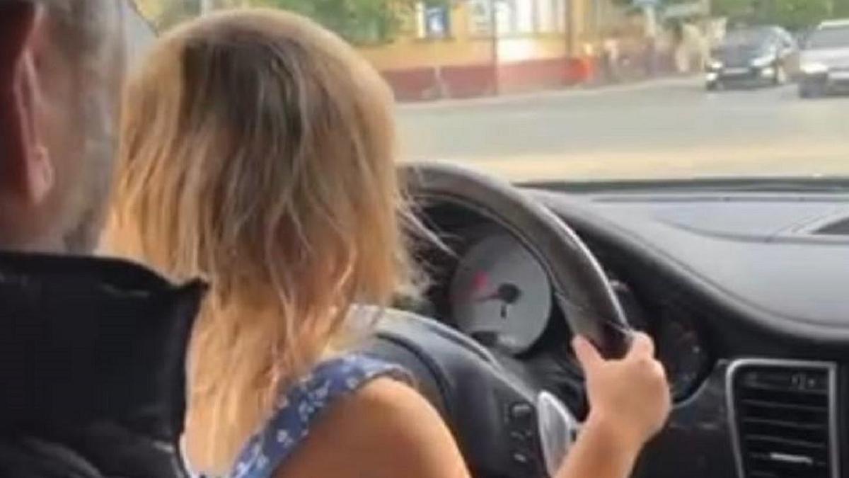 Ер адамның алдында отырып, көлік айдаған кішкентай қыз Ер адамның алдында отырып, көлік айдаған кішкентай қыз