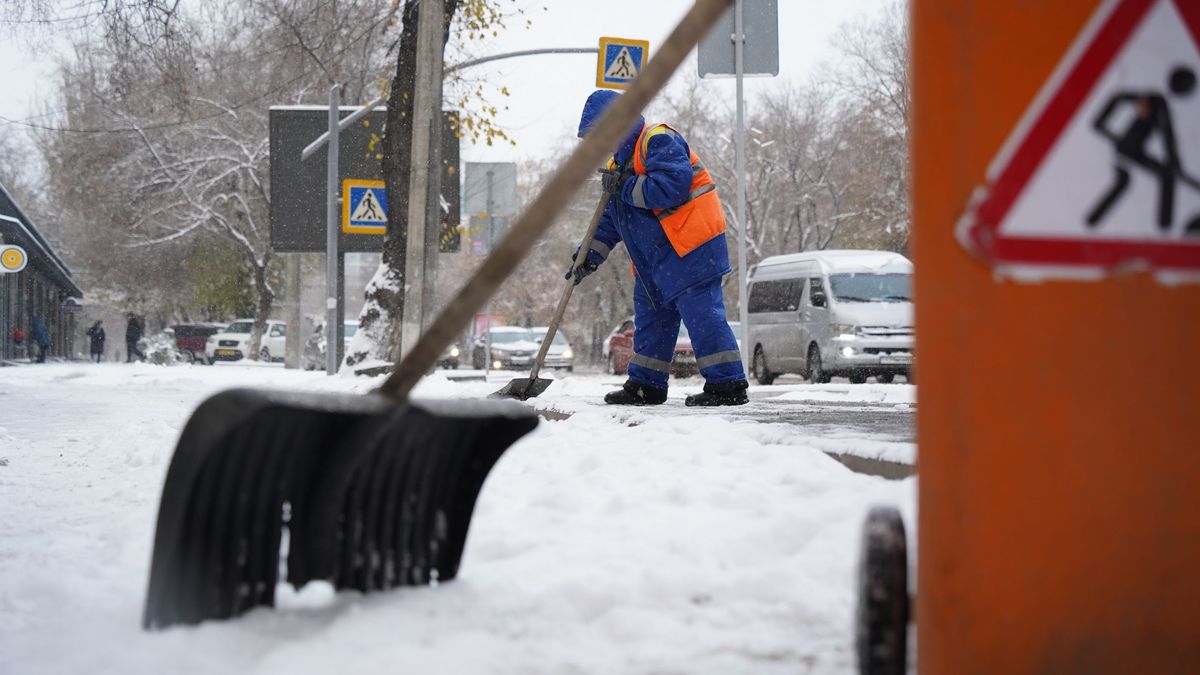 қар тазалап жатқан жұмысшы