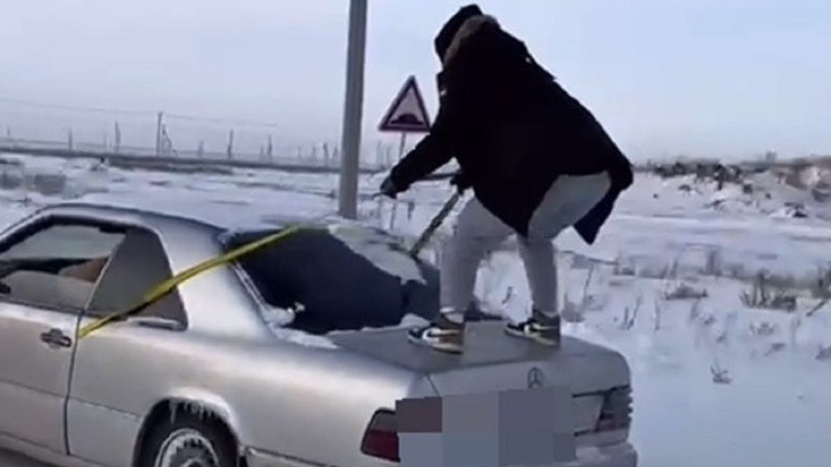 Мужчина на багажнике авто