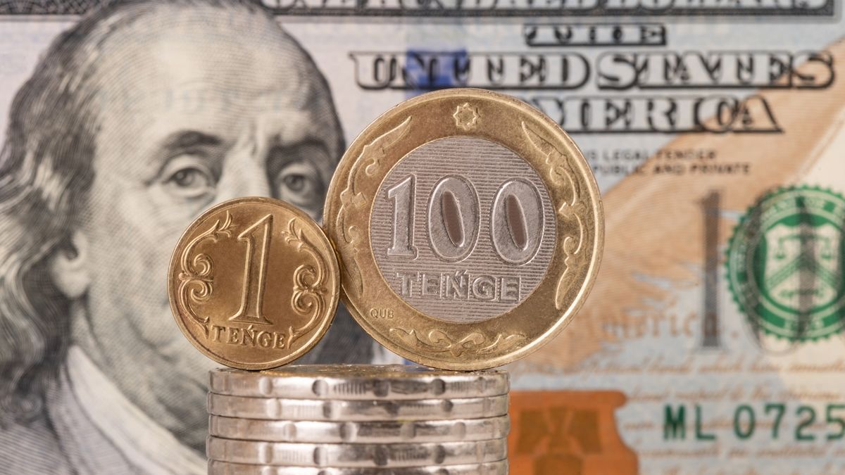 Монеты тенге на фоне доллара