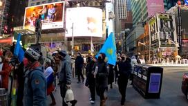Люди несут в руках флаг Казахстана