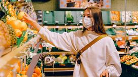 Девушка в маске покупает продукты