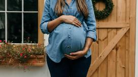 Беременная женщина поддерживает живот