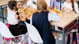 Дети едят за столом в столовой