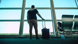Мужчина держит сумку с вещами в аэропорту