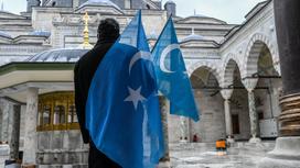 Демонстрант с флагом Восточного Туркестана около мечети в Турции