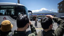 Туристы фотографируются на фоне горы Фудзи в Японии