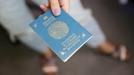 Девушка держит в руке казахстанский паспорт