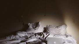 Смятая постель с ноутбуком