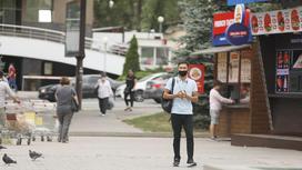 Мужчина в маске идет по улице Алматы