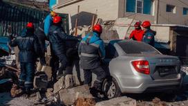 Спасатели убирают обломки здания с машины