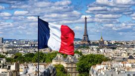 Флаг Франции на флагштоке в Париже на фоне Эйфелевой башни