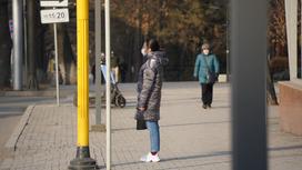 Девушка стоит в маске на улице