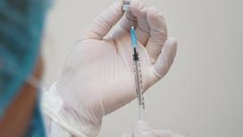 Медсестра набирает вакцину в шприц