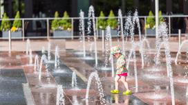 Ребенок гуляет возле фонтана