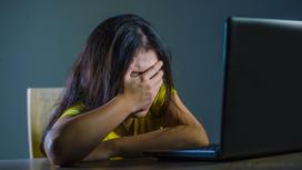 Женщина грустит за ноутбуком