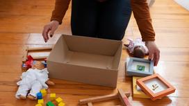 Женщина работает с коробкой и детскими игрушками