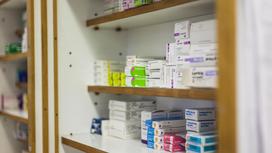 Упаковки с лекарствами лежат на полке в аптеке