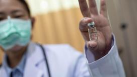 Медработник держит в руках ампулу с вакциной Sinovac