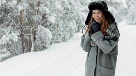 Девушка в пальто в зимнем лесу