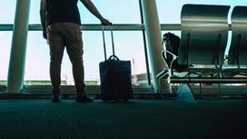 Мужчина с чемоданом в аэропорту