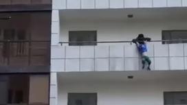 Мальчик повис на перилах балкона