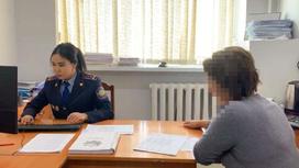 Женщина сидит в кабинете с девушкой-полицейским