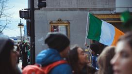 Люди на улице держат флаг Ирландии