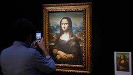 Посетитель фотографирует картину "Мона Лиза"