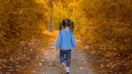 Маленькая девочка гуляет в парке