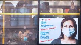 Плакат с девушкой в маске на окне автобуса