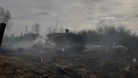 пожарные работают на месте сгоревшего дома