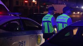Патрульные полицейские стоят возле служебных авто