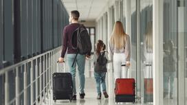 Папа, мама и ребенок с чемоданами идут по коридору аэропорта