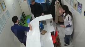 Мужчина с ножом в руках стоит в холле стоматологии