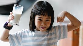 Ребенок держит стакан молока