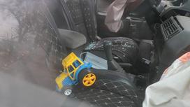 Салон машины с детской игрушкой на сидении