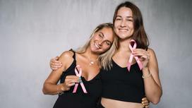 Две девушки держат розовые ленточки