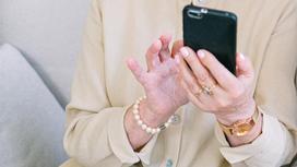 Женщина держит в руках телефон