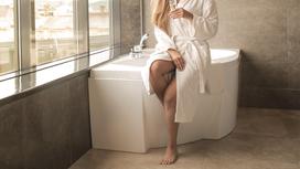 Девушка в белом халате в ванной в отеле