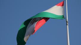 Флаг Таджикистана развевается на ветру на фоне неба