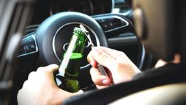 Водитель открывает бутылку пива в машине